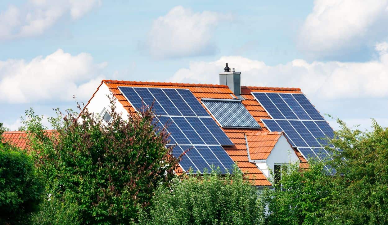 Home surrounded by trees with solar panels on the roof