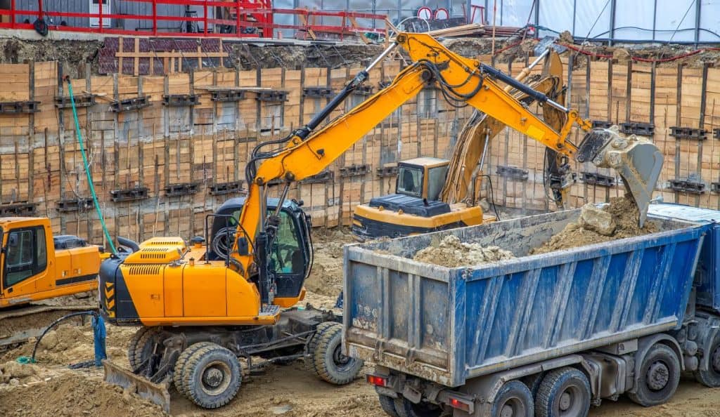 Wheeled excavator filling a dump truck with dirt and rocks