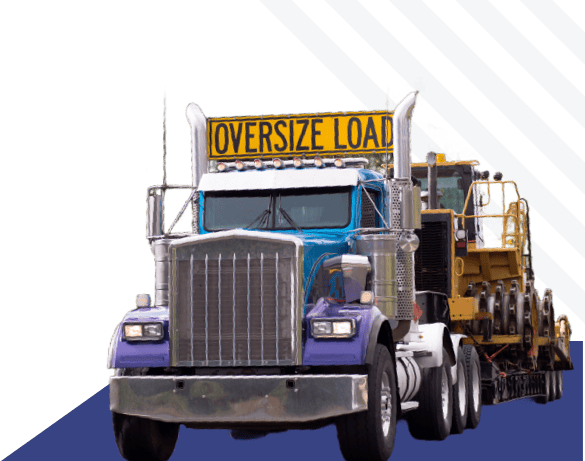 Large transport truck with oversize load warning sign carrying industrial equipment on highway.