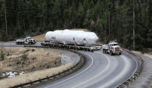 Oversize load convoy navigating mountain curve