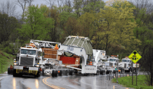 Oversize load heavy-haul truck convoy in rain