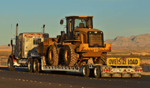 Semi truck hauling wheel loader oversize load