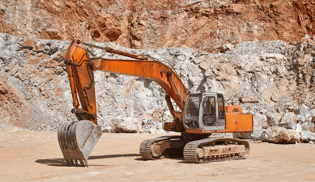 Orange excavator at rocky quarry or mining site.