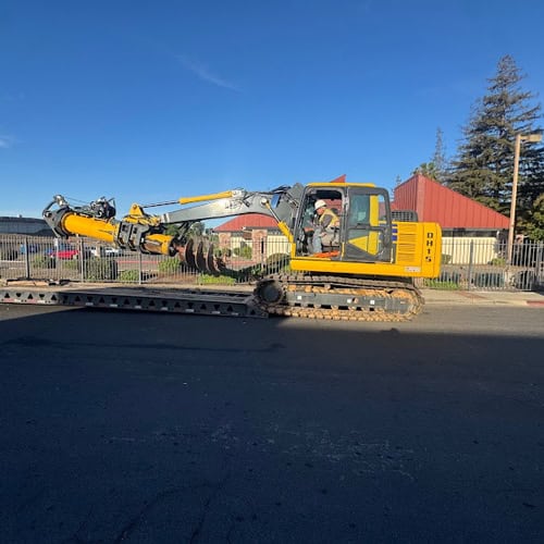 Yellow Komatsu-based directional drill loaded on RGN trailer